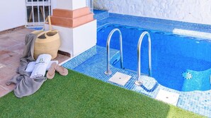 A swimming pool with two metal ladders, a small white step, and a drain cover. - El Campanario El Bosque by Ruralidays (Cádiz)