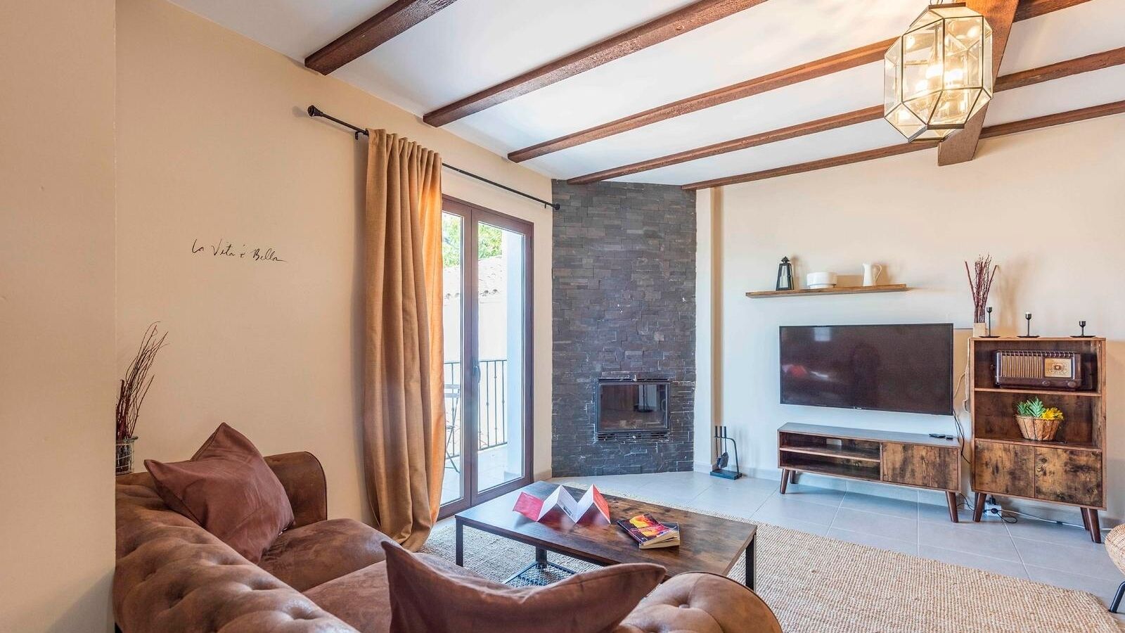 Una sala de estar con sofá, mesa de centro, televisor y chimenea.
