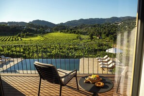 A balcony with a pool, lounge chairs, and a table with snacks. - Quinta de Cypriano - Wine & Nature (Ponte da Barca)