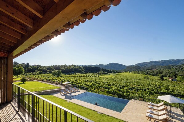 Una piscina con vistas a viñedos y colinas.