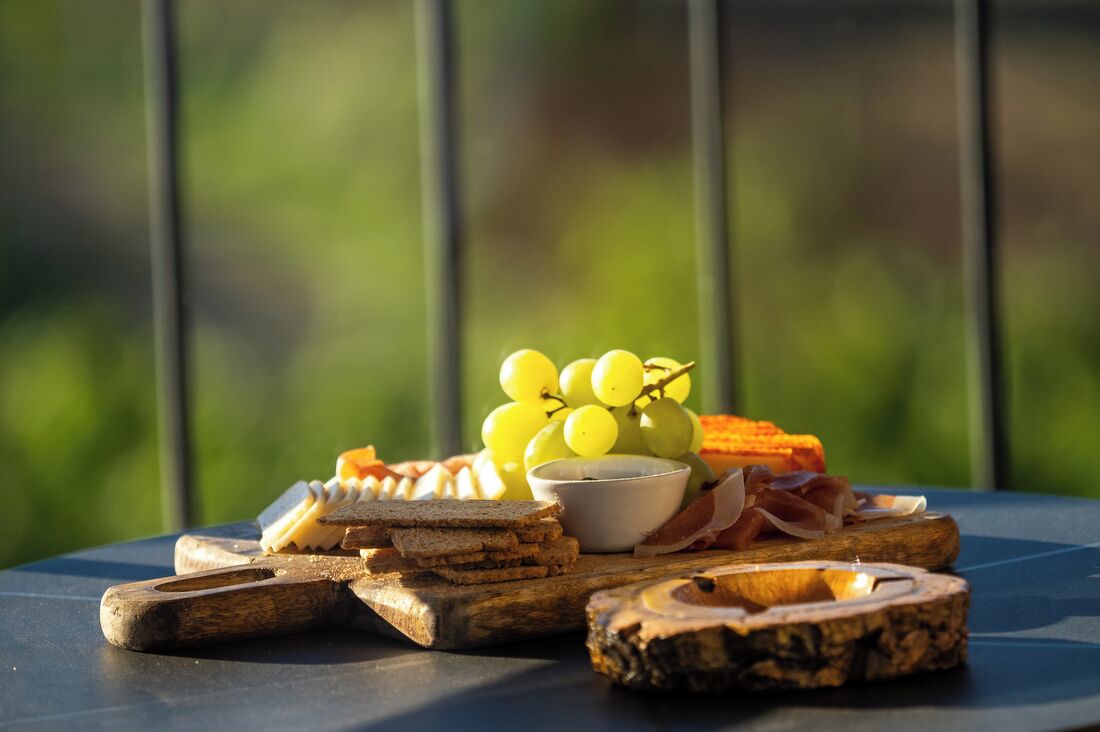 A table with various food items including bread, cheese, and grapes.