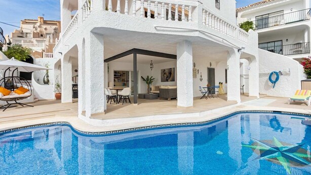 A white building with a pool, outdoor seating, and a balcony. - Casa Jerez 14 en Nerja  by Ruralidays (Málaga)