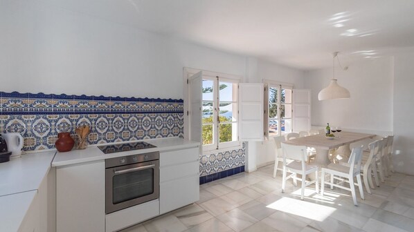 Una cocina moderna con armarios blancos, horno empotrado y salpicadero de azulejos.