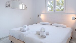 A hotel room with a bed, two towels, a window, and a wall-mounted mirror. - Finca Kriek Rincón de la Victoria by Ruralidays (Málaga)