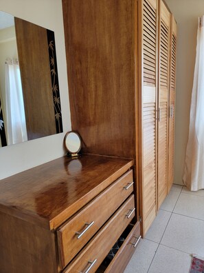 A wooden dresser with drawers and a mirror.