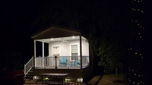 A small, single-story house with a covered porch, a pool, and a patio area.