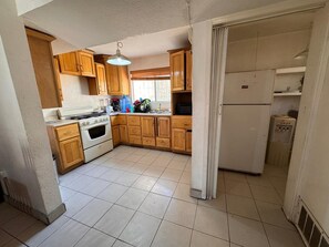 Une cuisine dotée de meubles de rangement en bois, d’une cuisinière, d’un réfrigérateur et d’un distributeur d’eau.