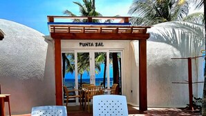 A poolside area with two white lounge chairs, a small pool, and a building labeled "PUNTA SAL."