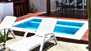 Zona de piscina con sillones de descanso y un área de estar techada identificada como 'TORNADE'.