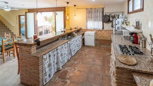 A kitchen with a central island, a built-in dishwasher, and a gas stove.