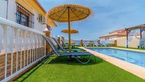 A pool area with a slide, lounge chairs, and umbrellas.