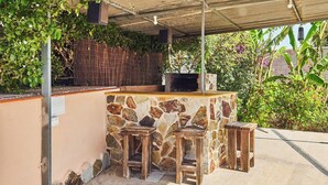 An outdoor bar area with a stone counter and wooden stools. - El Mirador Jerez de la Frontera by Ruralidays (Cádiz)