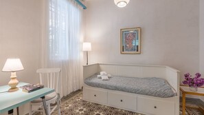 A small, neatly arranged bedroom with a single bed, a bedside table with a lamp, a chair, and a framed picture on the wall. - Flamenco y Sol Lecrín by Ruralidays (Granada)