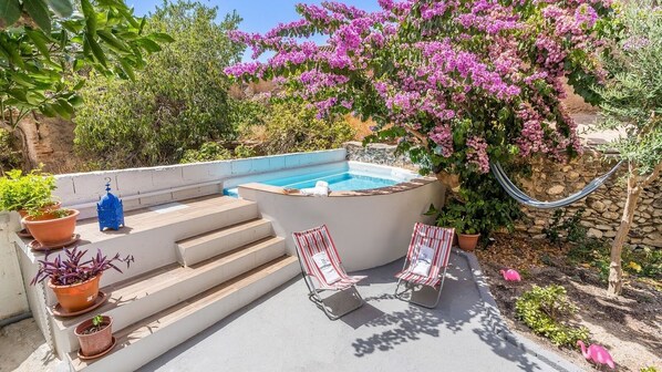 A rooftop pool area with steps leading to the pool, two striped lounge chairs, and potted plants. - Flamenco y Sol Lecrín by Ruralidays (Granada)