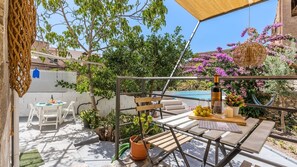 A patio with outdoor seating, a table with a bottle and glasses, and a hammock. - Flamenco y Sol Lecrín by Ruralidays (Granada)