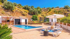 A pool area with lounge chairs, a barbecue area, and a basketball hoop. - Casa El Limonero Cómpeta by Ruralidays (Málaga)