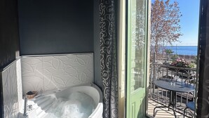 A bathroom with a large bathtub, a shower, and a view of the outdoors. - B&B I Puritani (Catania)