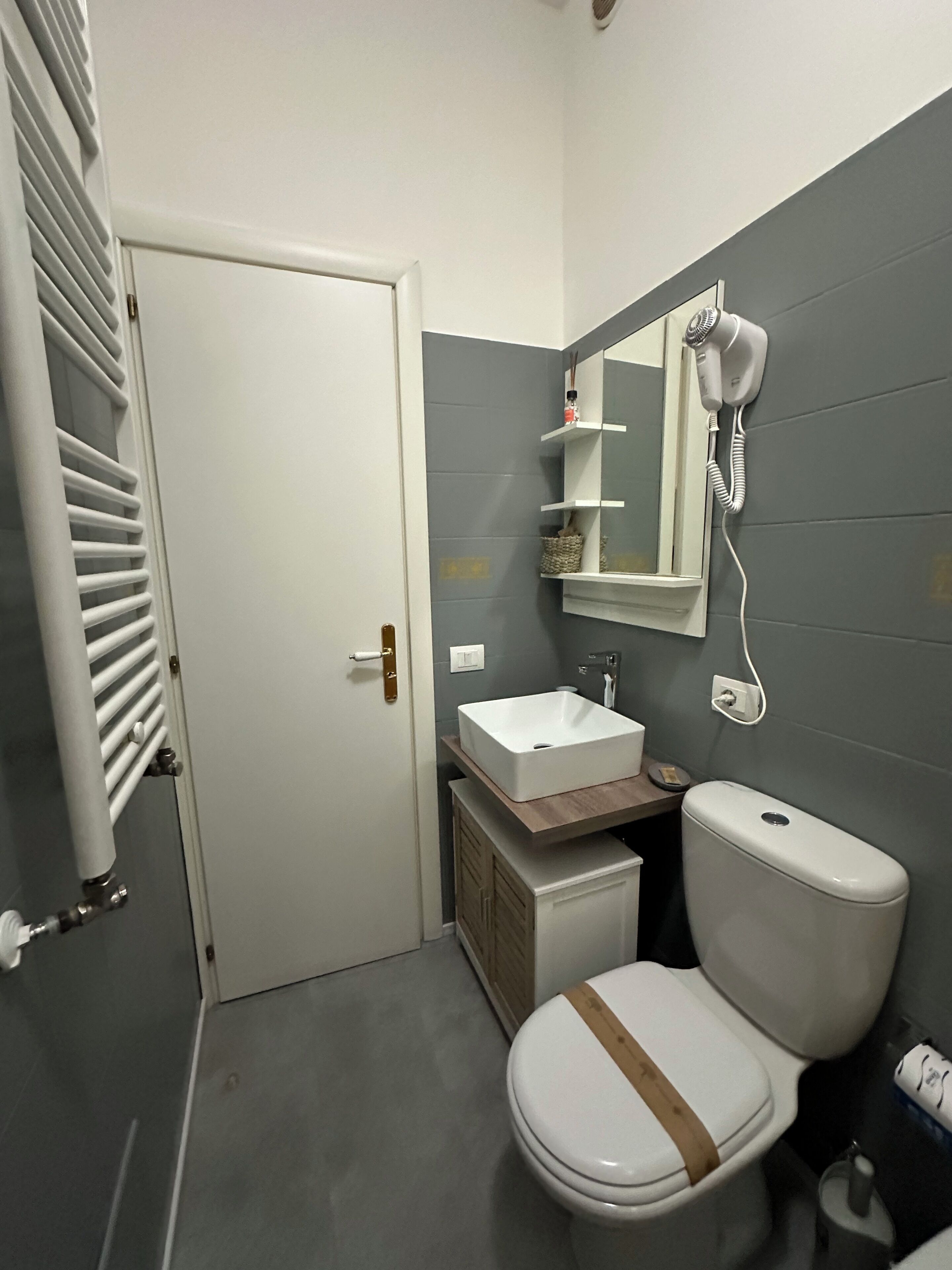 A small bathroom with a toilet, sink, and mirror.