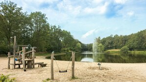 A sandy beach area with a swing set and a pond. - Pet friendly home in Mariënberg (Mariënberg)