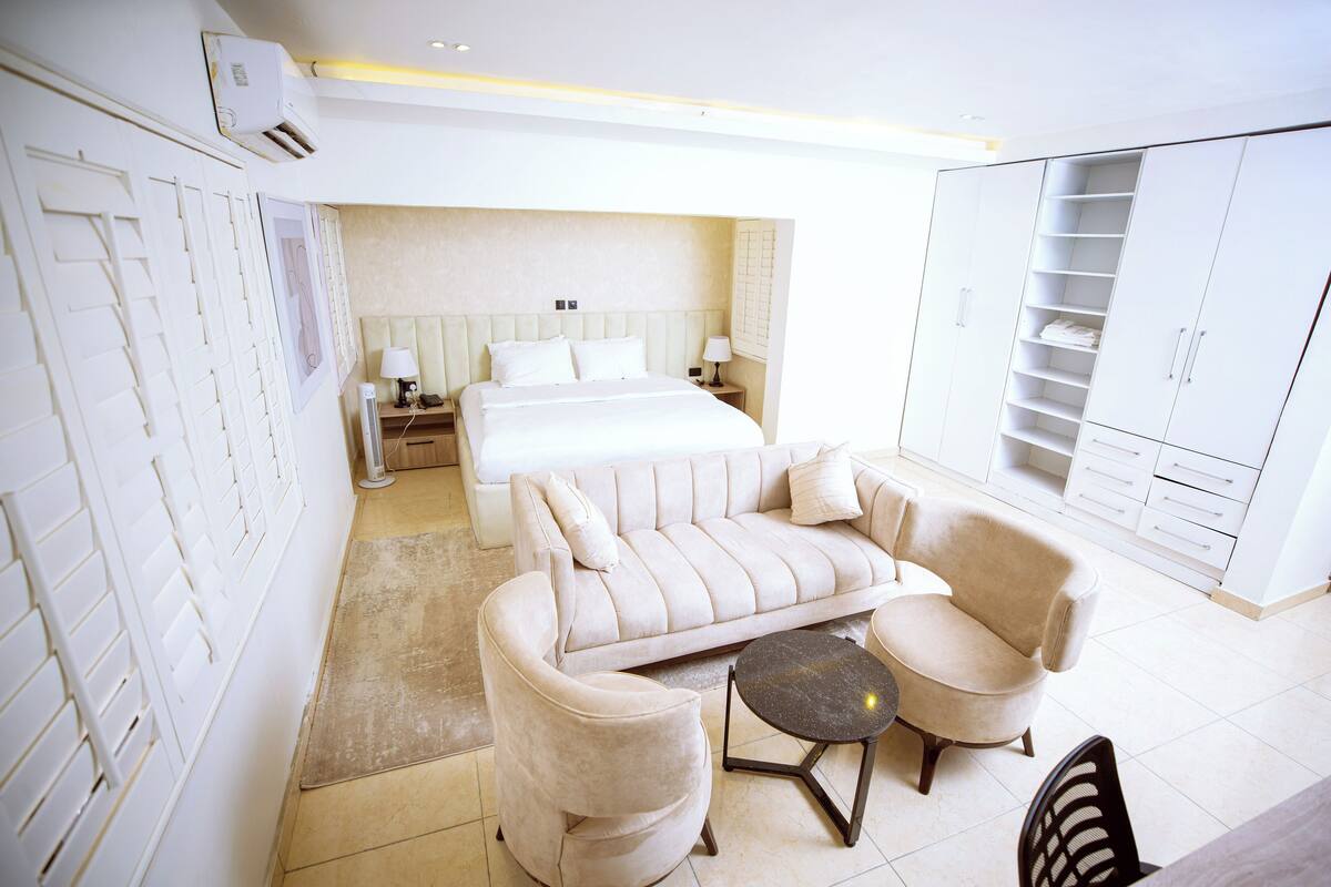 Une chambre d’hôtel comprenant un lit, un canapé, une table basse et une armoire.