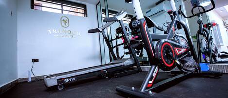 A gym with exercise equipment, including a stationary bike and a treadmill.