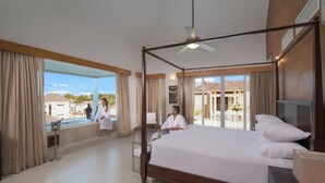 A spacious bedroom with a large bed, a ceiling fan, and a view of the outside. - Beach Dreams (Puerto Plata)