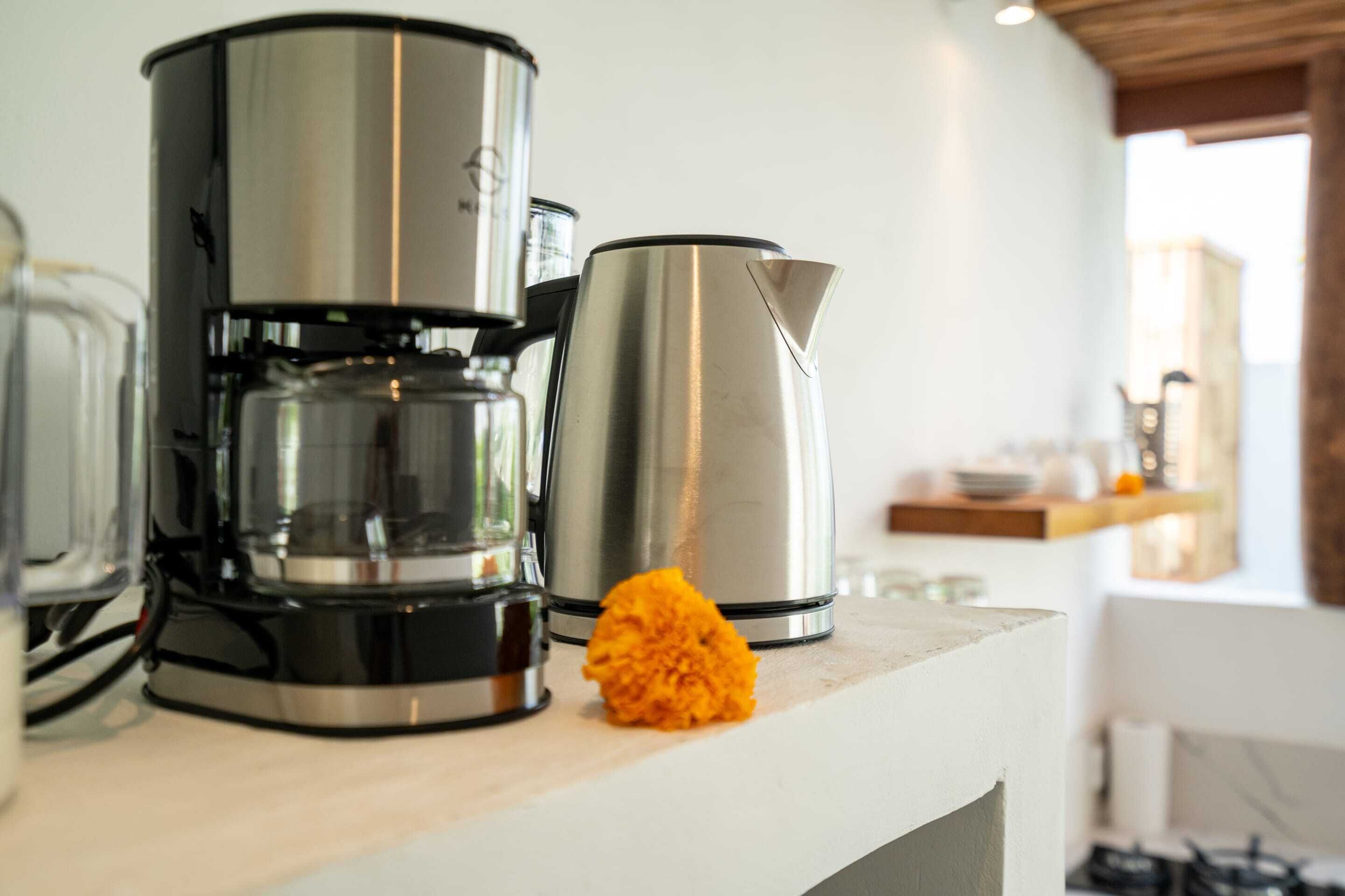 Una encimera de cocina con una cafetera y un hervidor.