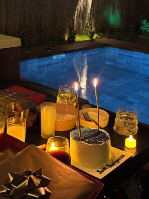 A poolside setting with a birthday cake, candles, and various drinks. - Sesa Sapanca (Sapanca)