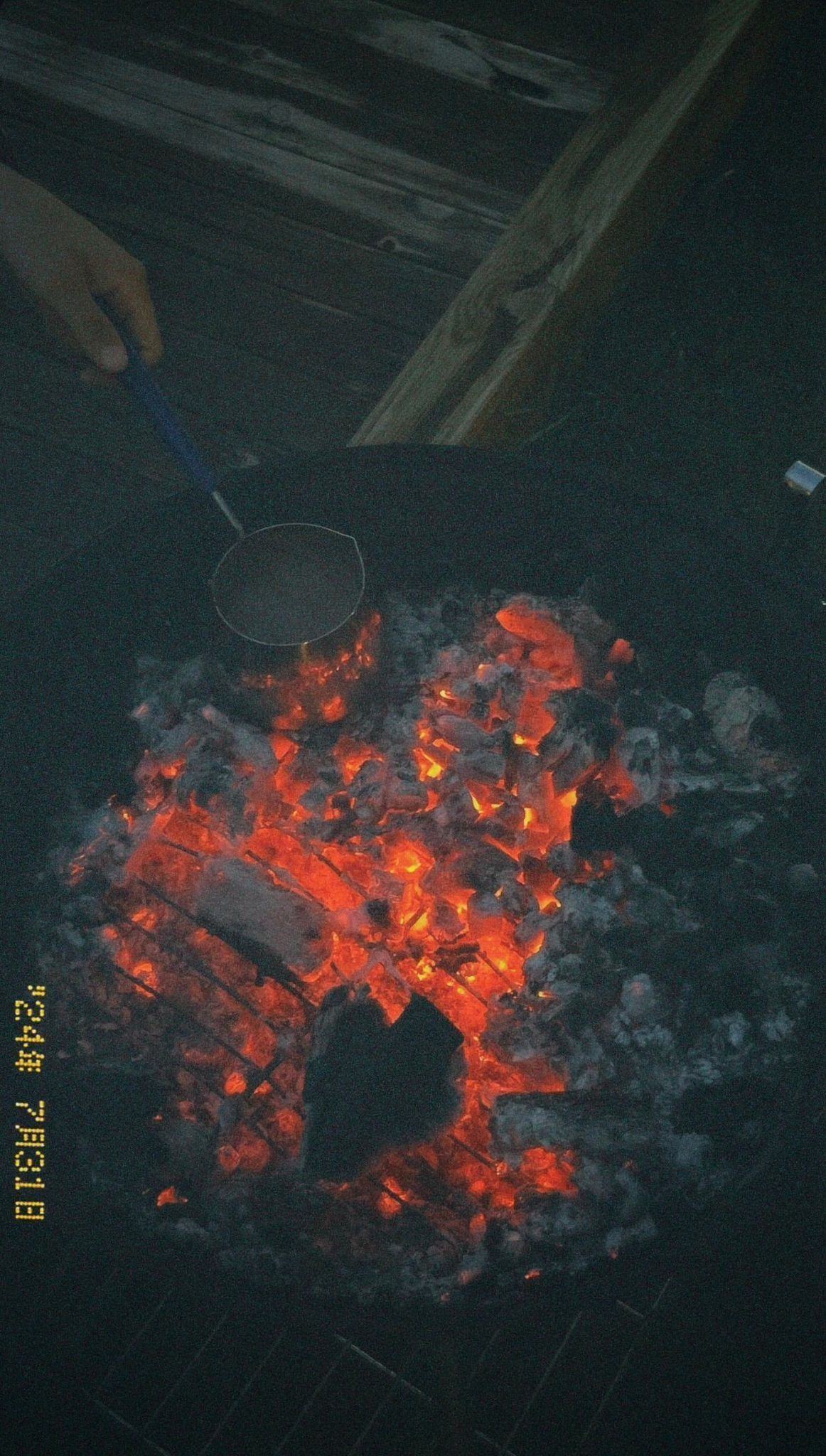 Een kolenvuur met een metalen pan erop.
