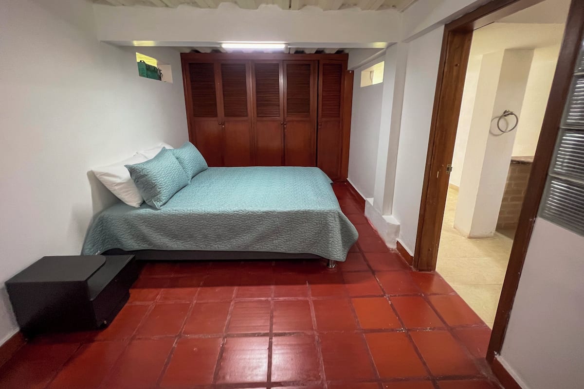 Une chambre à coucher avec un lit, une armoire et une petite table.