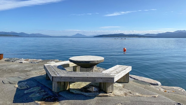 A wooden bench and table by a calm lake with mountains in the background. - Gorgeous home in Fiksdal with WiFi (Fiksdal)