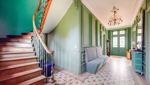 A staircase with wooden steps and a handrail, leading to a room with a patterned carpet and a blue sofa. - Pet friendly home in Chabris with WiFi (Chabris)