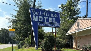 A motel sign with a blue background and white lettering, indicating it is air-conditioned. - Bel-Aire Motel Tuscaloosa (Tuscaloosa)