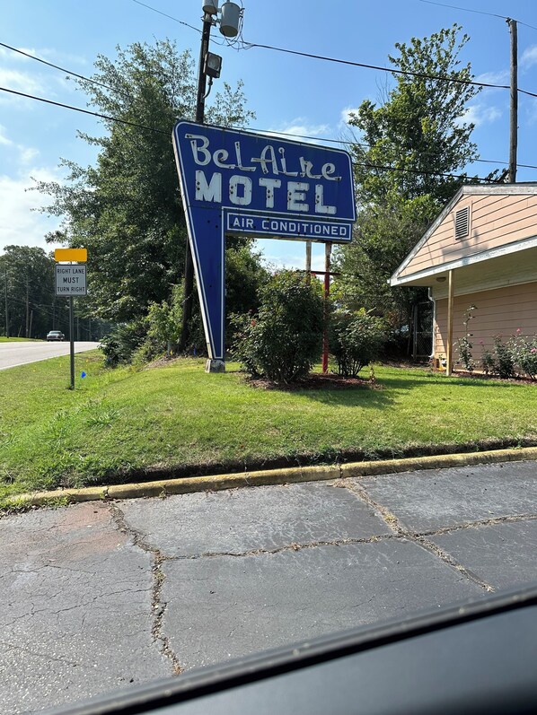 Señal de motel con fondo azul y letras blancas, indicando que tiene aire acondicionado.
