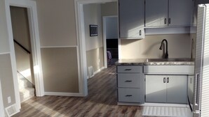Una cocina moderna con suelo de madera, ventilador de techo y armarios empotrados.