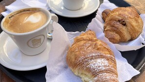 A table with a cup of coffee, a pastry, and a spoon. - HOLIDAY ROMA (Rome)