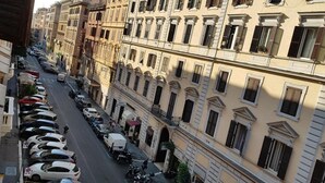A street view of a city with parked cars and buildings with multiple stories and balconies. - HOLIDAY ROMA (Rome)