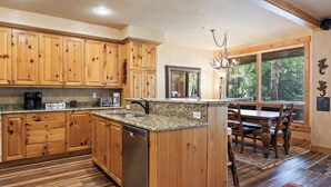 Cocina con armarios de madera, encimeras de granito y lavavajillas empotrado.