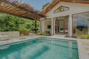 A modern house with a pool, large windows, and a covered patio area. - NOUR Villas (Belmopan)