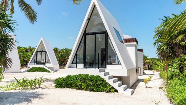Un edificio moderno dalla forma triangolare, con ampie finestre e una scala che conduce all'ingresso.