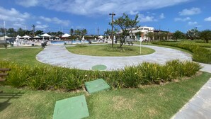 A public park with a circular walking path, benches, and a small tree. - Flat 110 Muro Alto CC by LaPlaya (Ipojuca)
