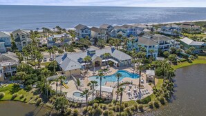 A resort with multiple buildings, a swimming pool, and a beachfront view.