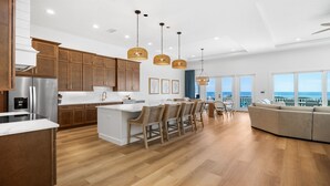 A modern kitchen with wooden cabinets, a central island, and pendant lighting.