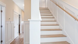 Una escalera con escalones de madera y paredes blancas.