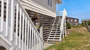 A wooden staircase leading to a house with a white exterior. - Shorely Bliss 3-Min Walk to Beach w/ Hot Tub (Kitty Hawk)