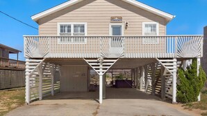 A two-story house with a balcony and a covered driveway. - Shorely Bliss 3-Min Walk to Beach w/ Hot Tub (Kitty Hawk)
