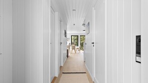 A long, narrow hallway with white walls and wooden floors. - 4 bedroom lovely home in Risør (Risør)