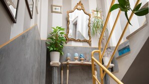 Eine Treppe mit goldener Geländer, Marmorwänden, einem Spiegel und Zimmerpflanzen.