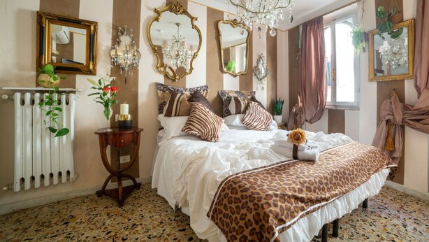 Ein Schlafzimmer mit Bett, einer Deckenleuchte, einem Heizkörper und einem Spiegel.