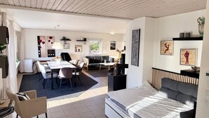 Una sala moderna con sofá, mesa de comedor y cama.